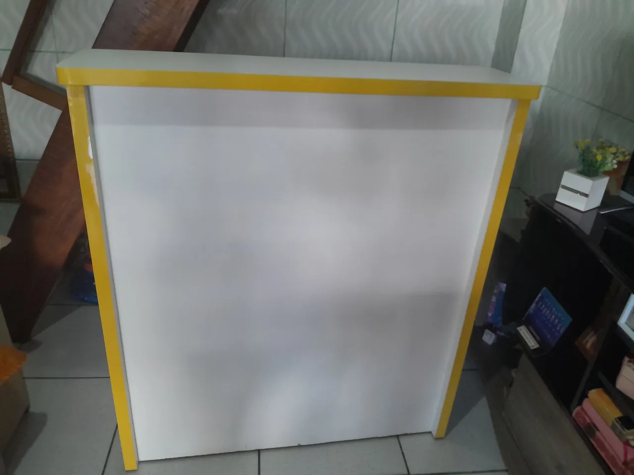 Balcão comercial branco com detalhes amarelos