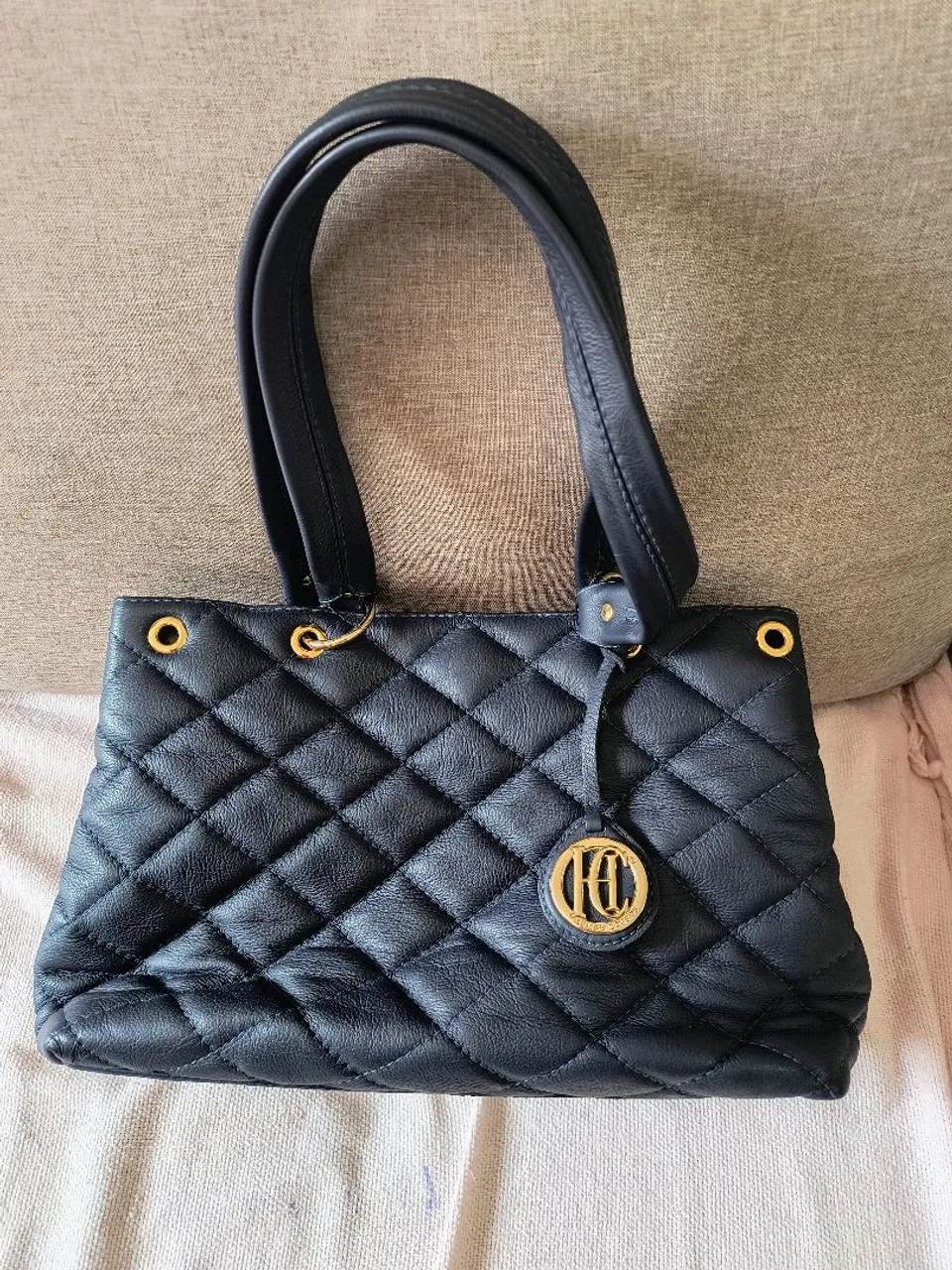 Bolsa de mão em couro azul com detalhes dourados