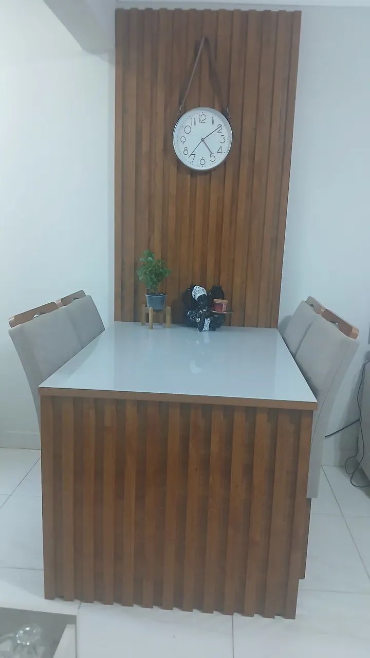 Mesa com cadeiras e painel ripado