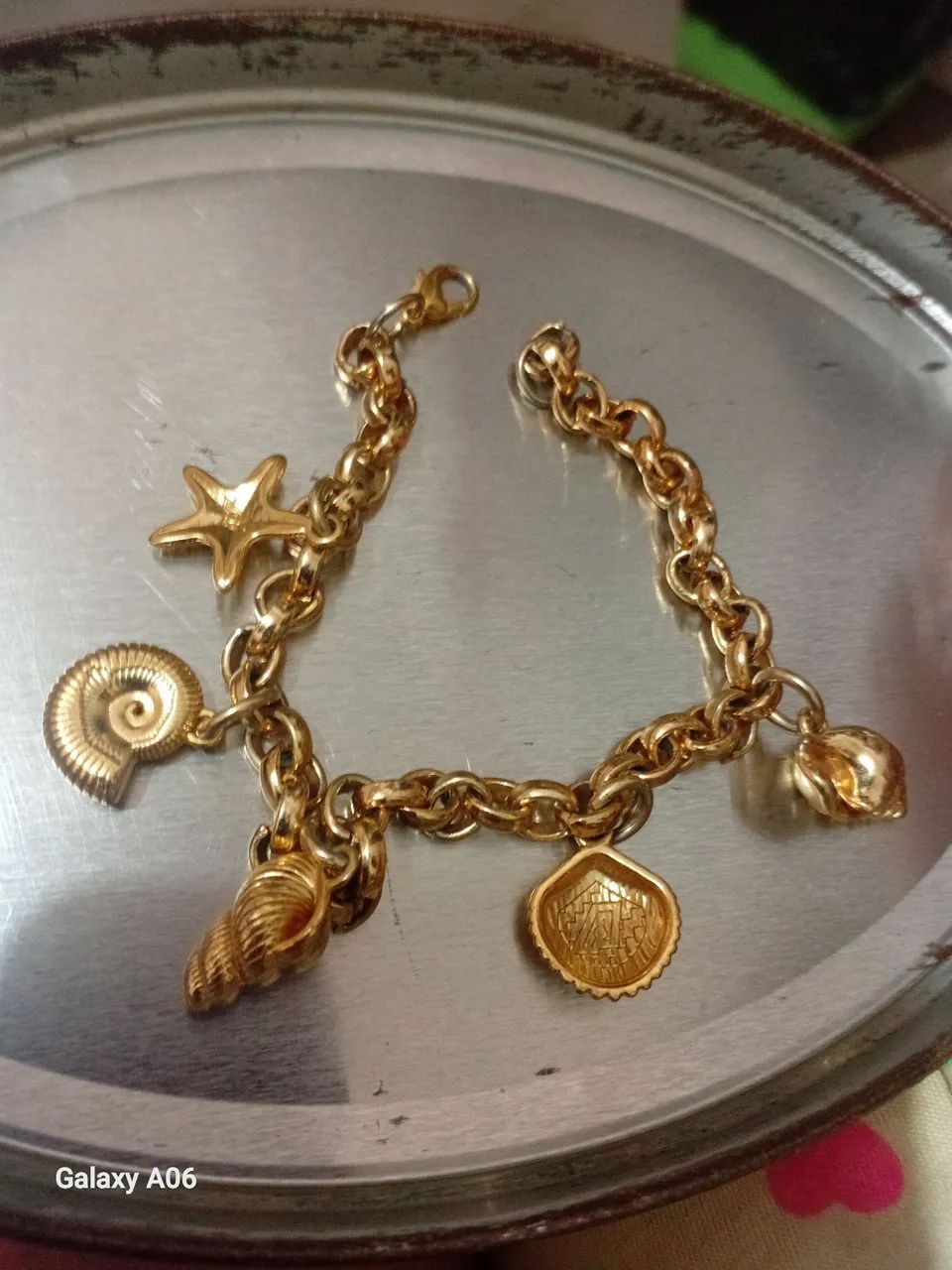 Pulseira charm dourada de conchas e estrela