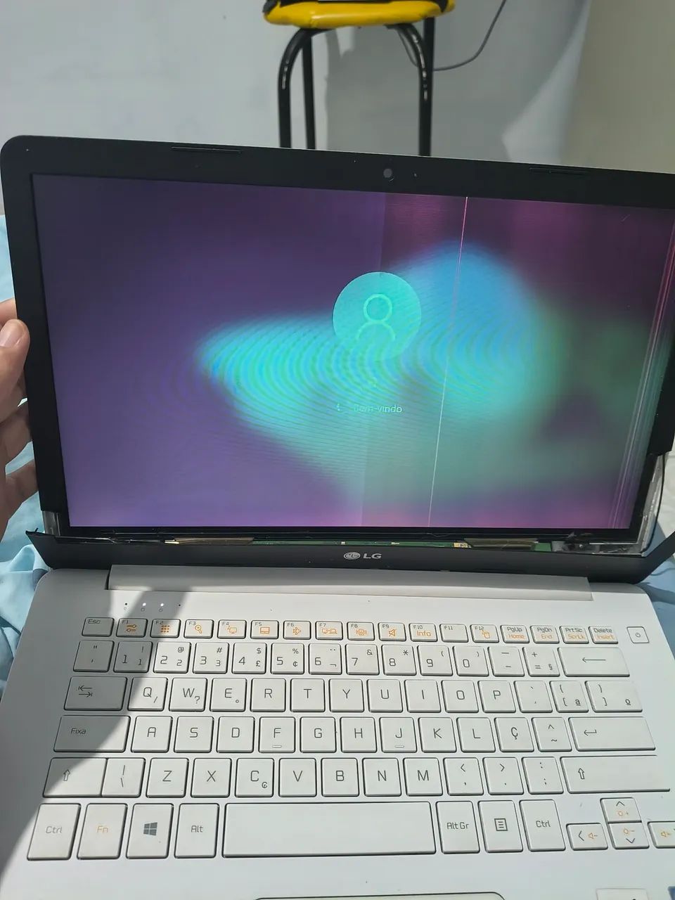 Notebook LG com carcaça da tela quebrada e tela com avaria de cores/listras