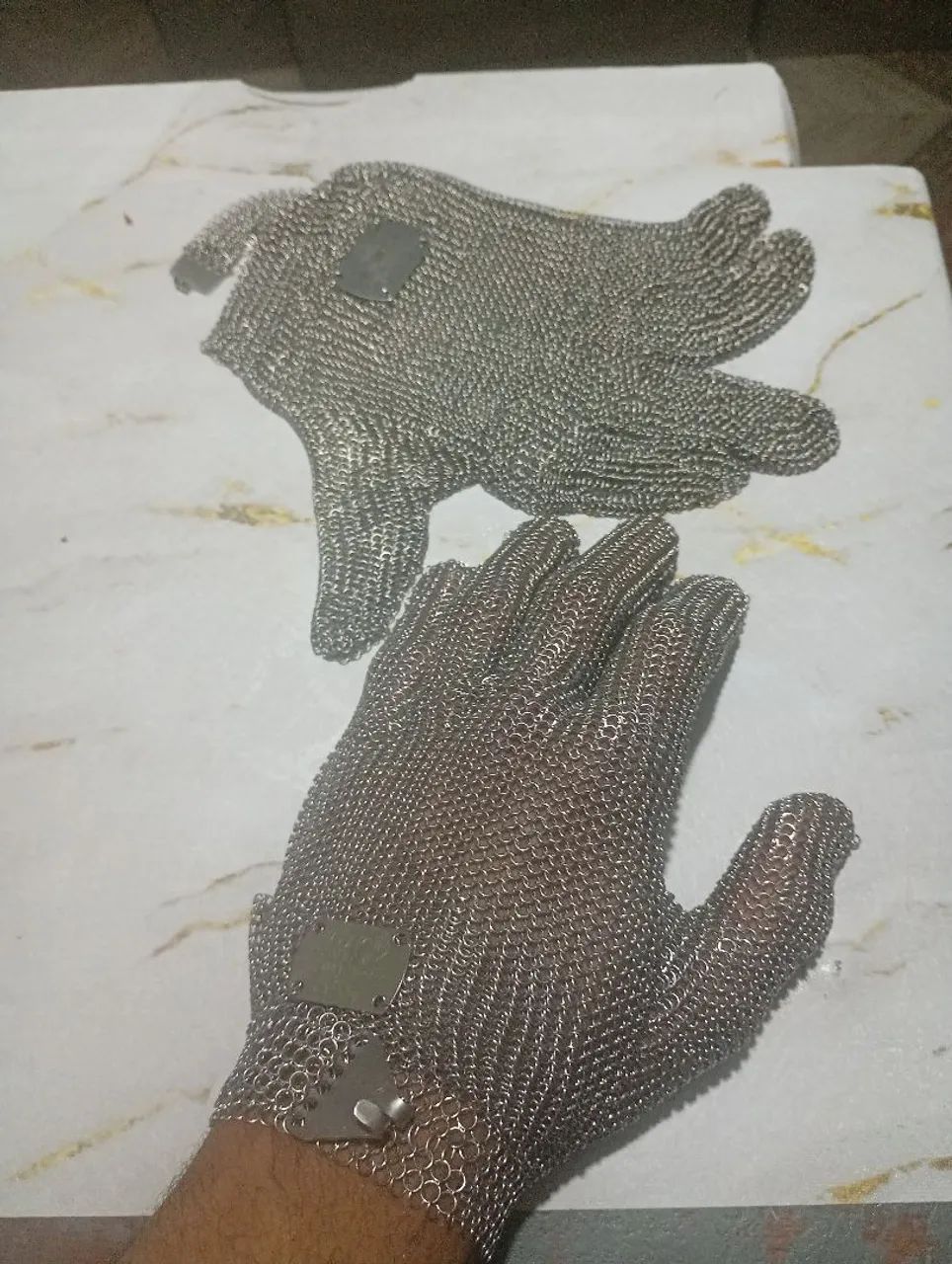 Duas luvas de malha de aço para açougue.
