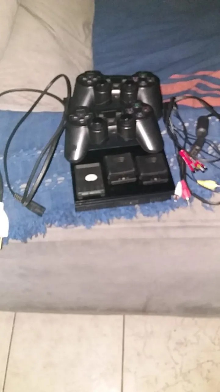 Um controle de PlayStation 2 e o PlayStation 2 Novo com
