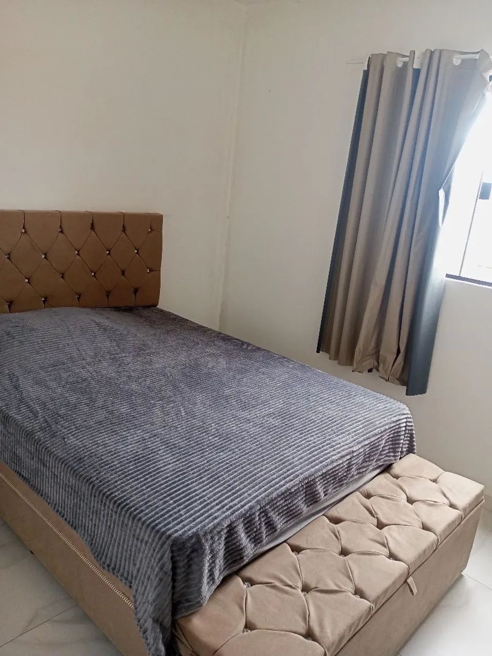 Cama de casal, com cabeceira e baú. 