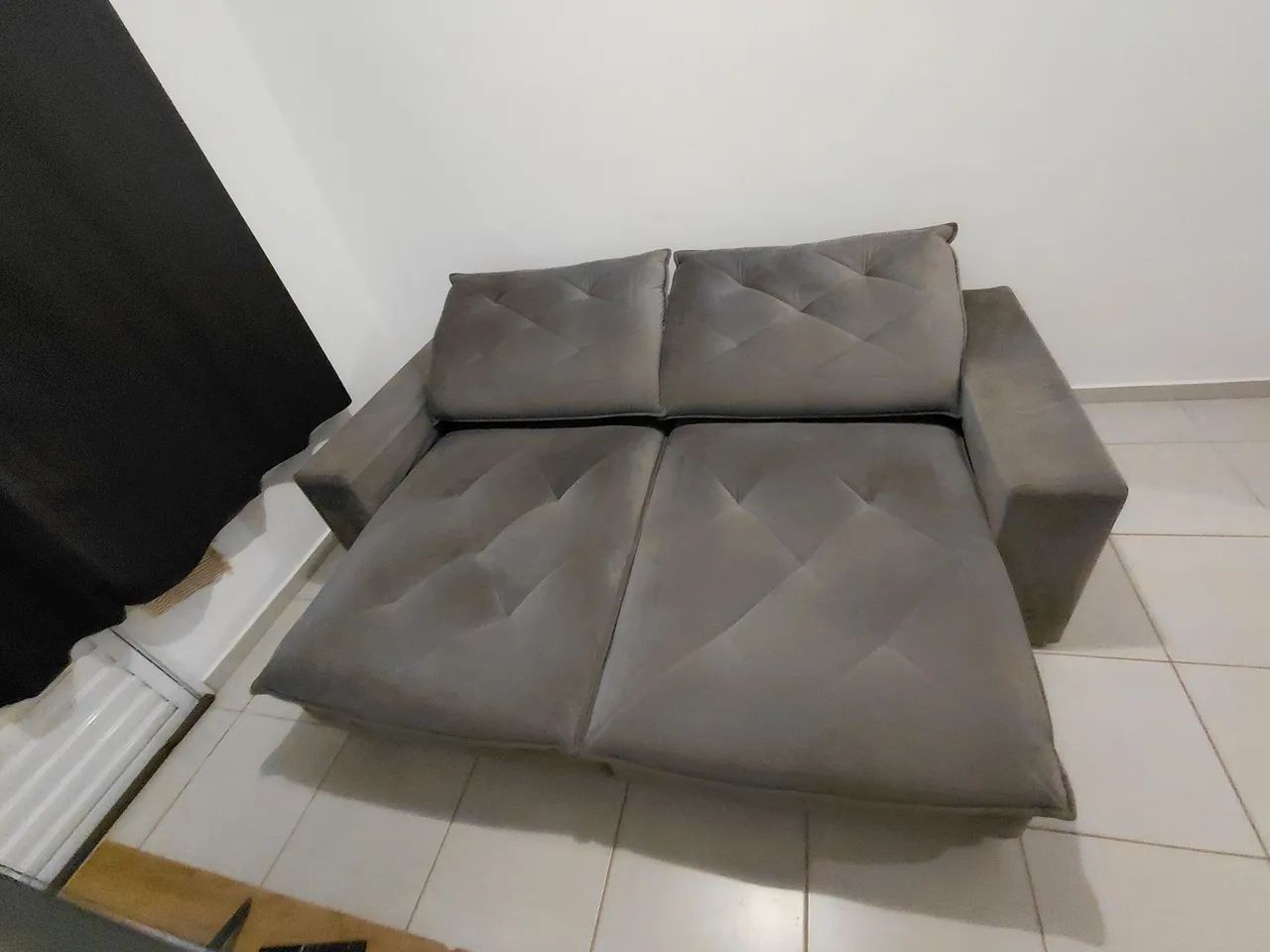 Sofá retrátil e reclinável cinza.