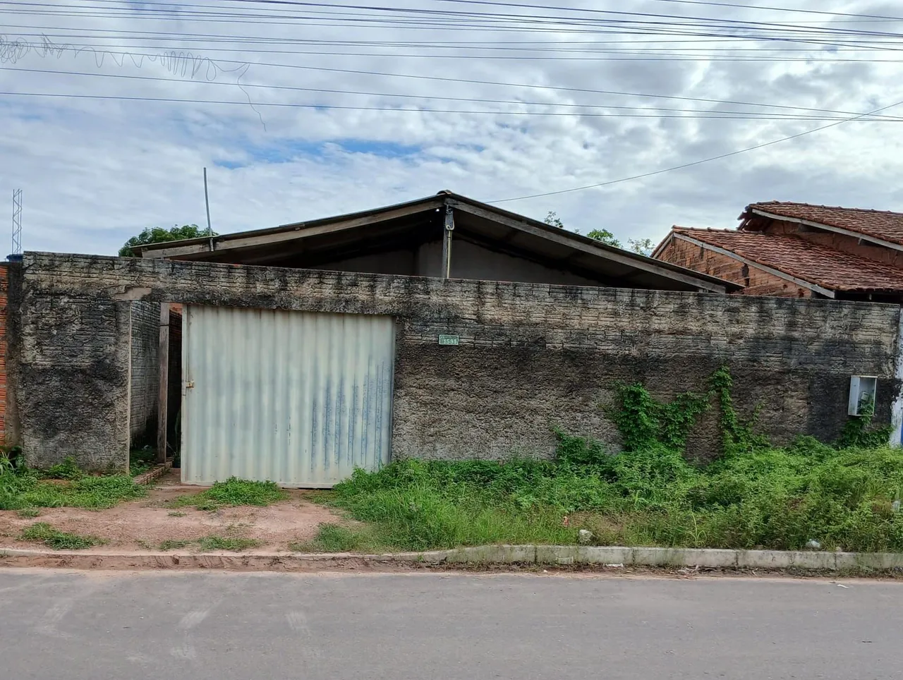Casa com sala, três quartos, dois banheiros, cozinha e quintal, toda murada.