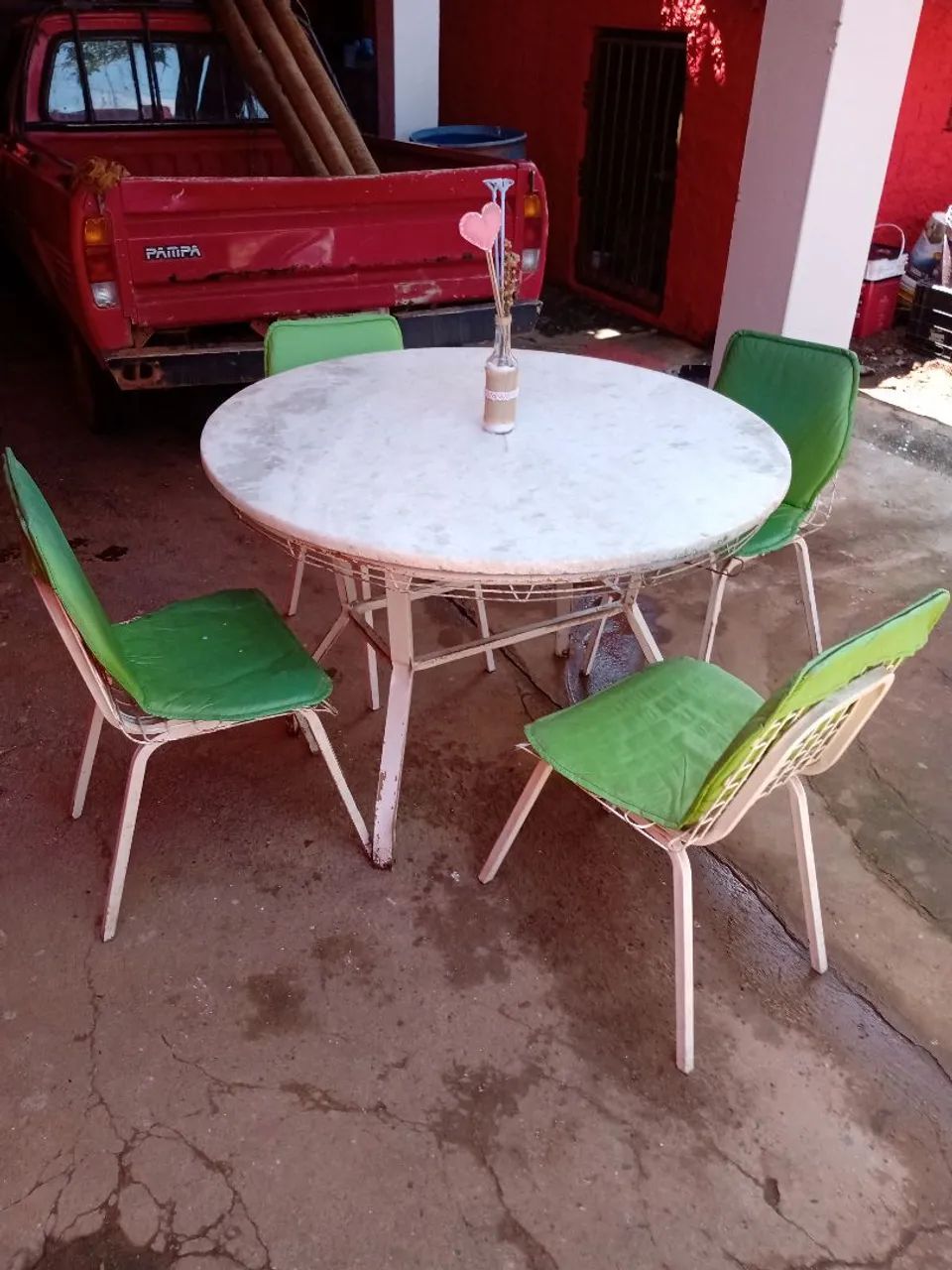 Mesa redonda com pedra de mármore branco  conservada,com 4 cadeiras em bom estado .