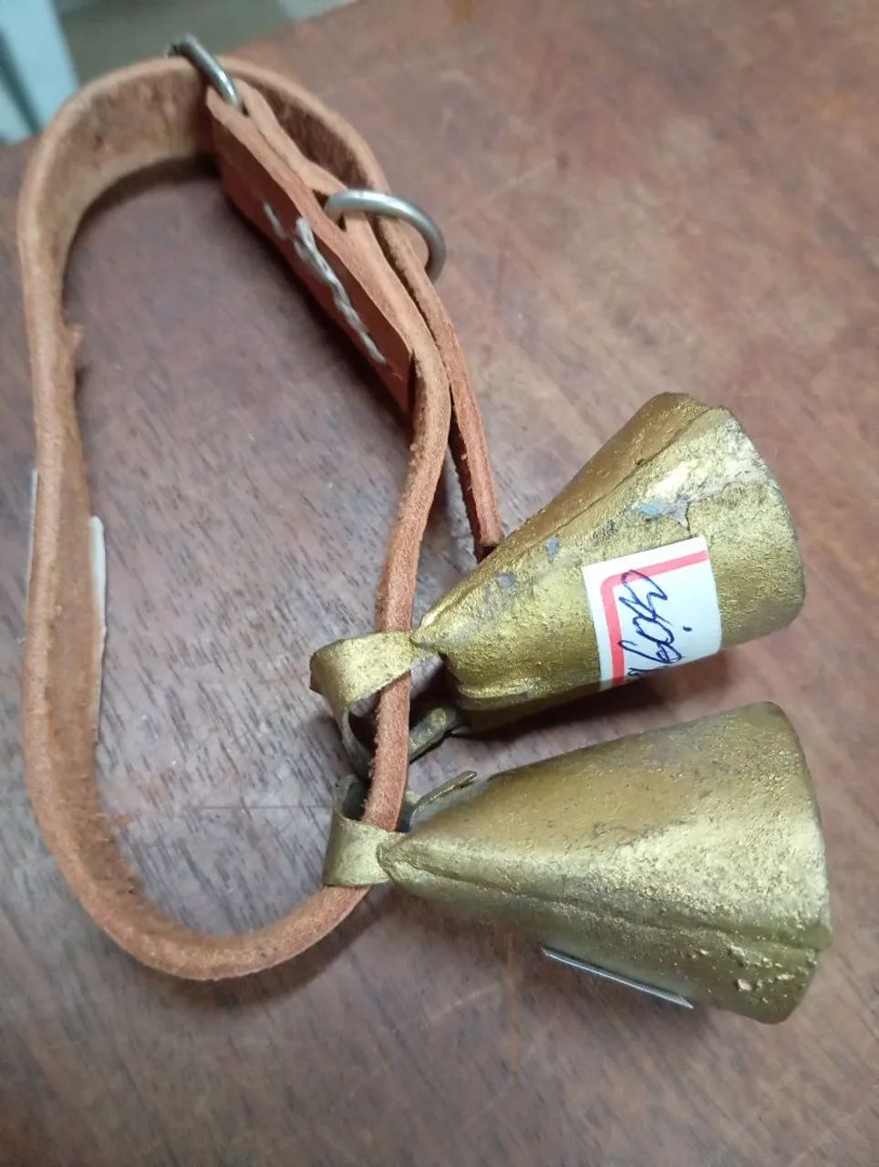 Comcerros de animais em bronze e couro.