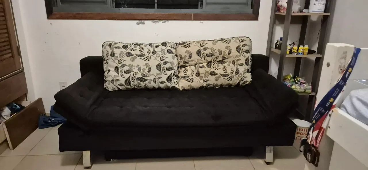 Sofá-cama preto com baú, braços ajustáveis e almofadas