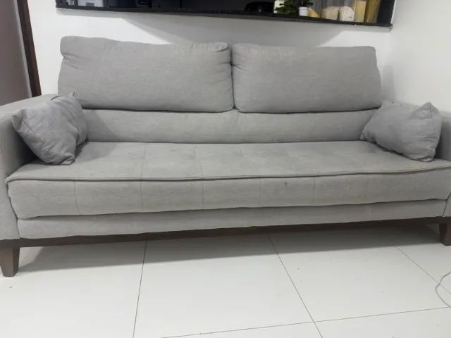 sofá de três lugares  de cor cinza 