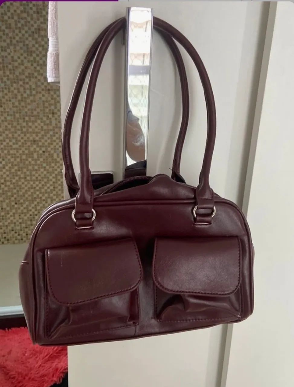 Bolsa de mão em couro vinho com bolsos frontais