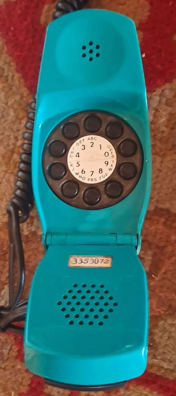 telefone trimline retrô anos 70, verde escuro com design clássico e discador rotativo.