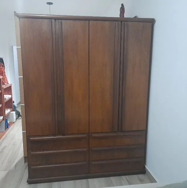 Armário de madeira maciça, na cor mogno, de 4 portas e 6 gavetas.