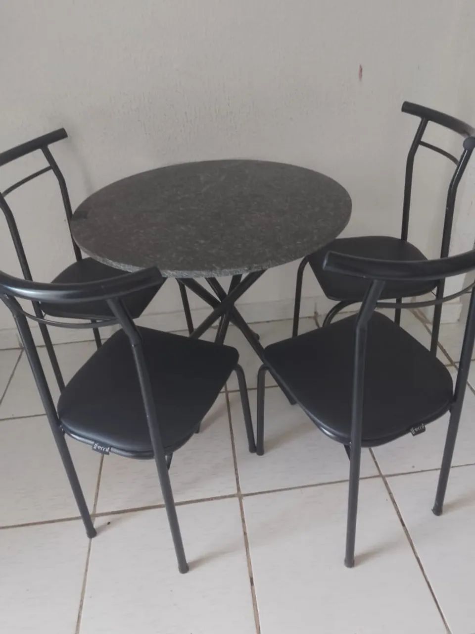 Mesa redonda, de quatro cadeiras.