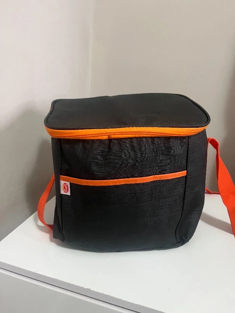 bolsa térmica na cor preta com detalhes em laranja