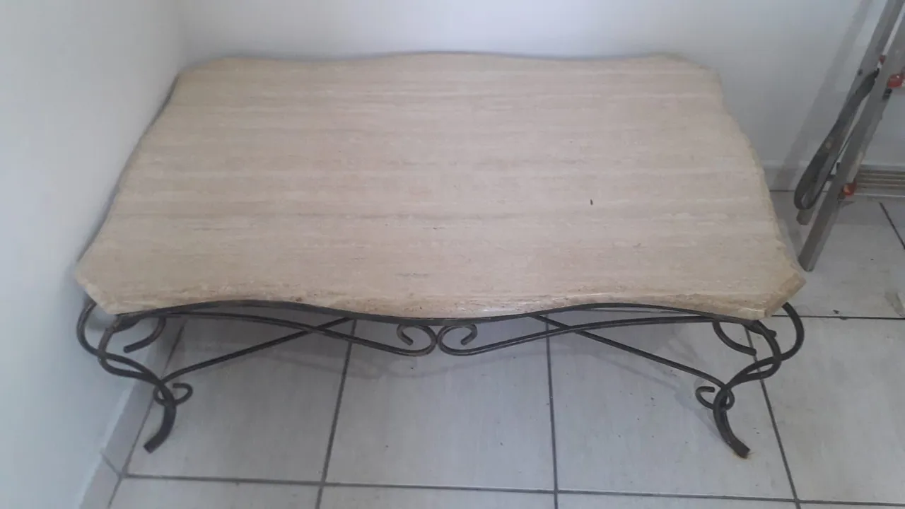 Mesa de centro com tampo em pedra e estrutura em ferro