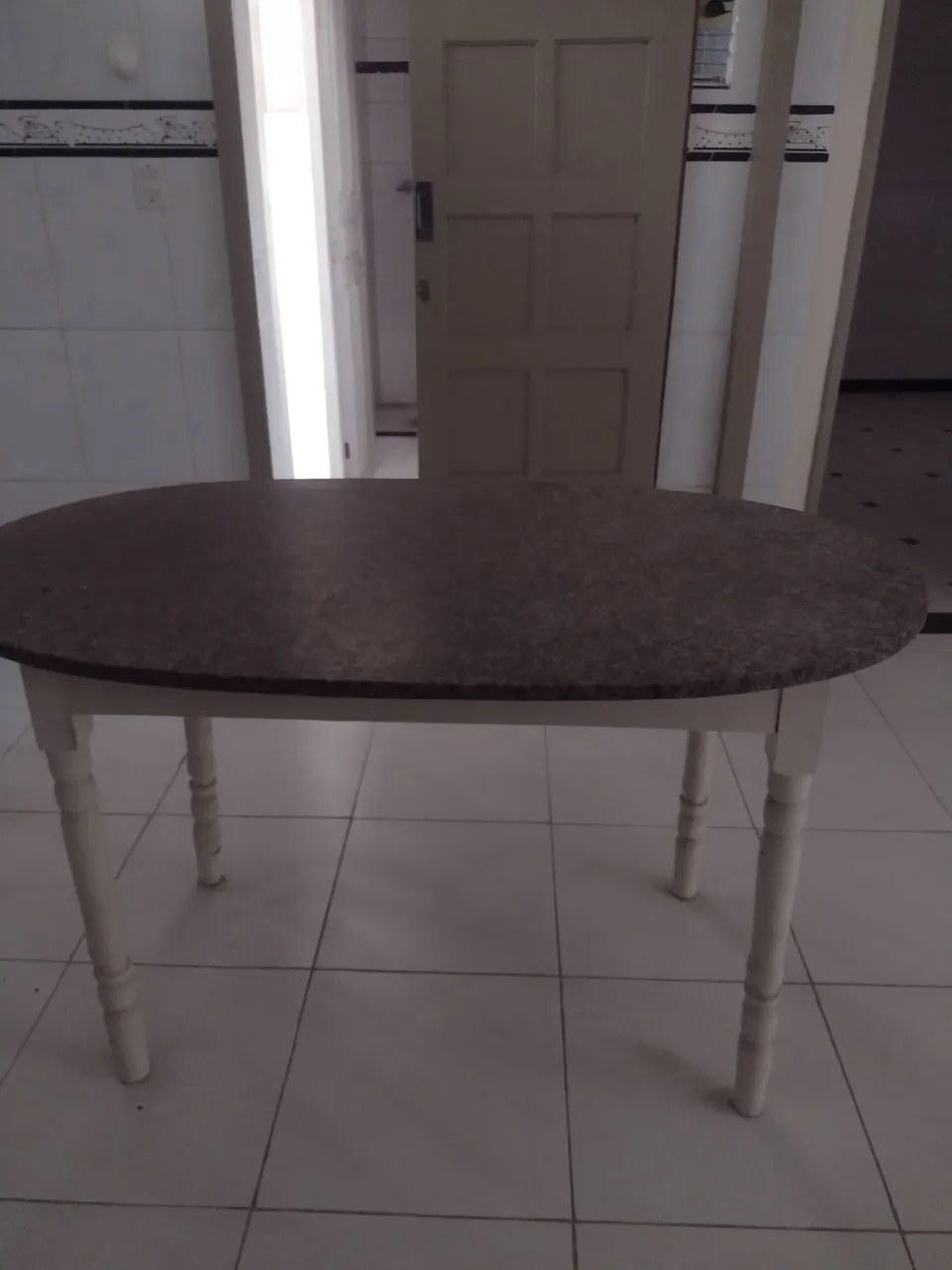 Mesa de jantar oval com tampo de granito