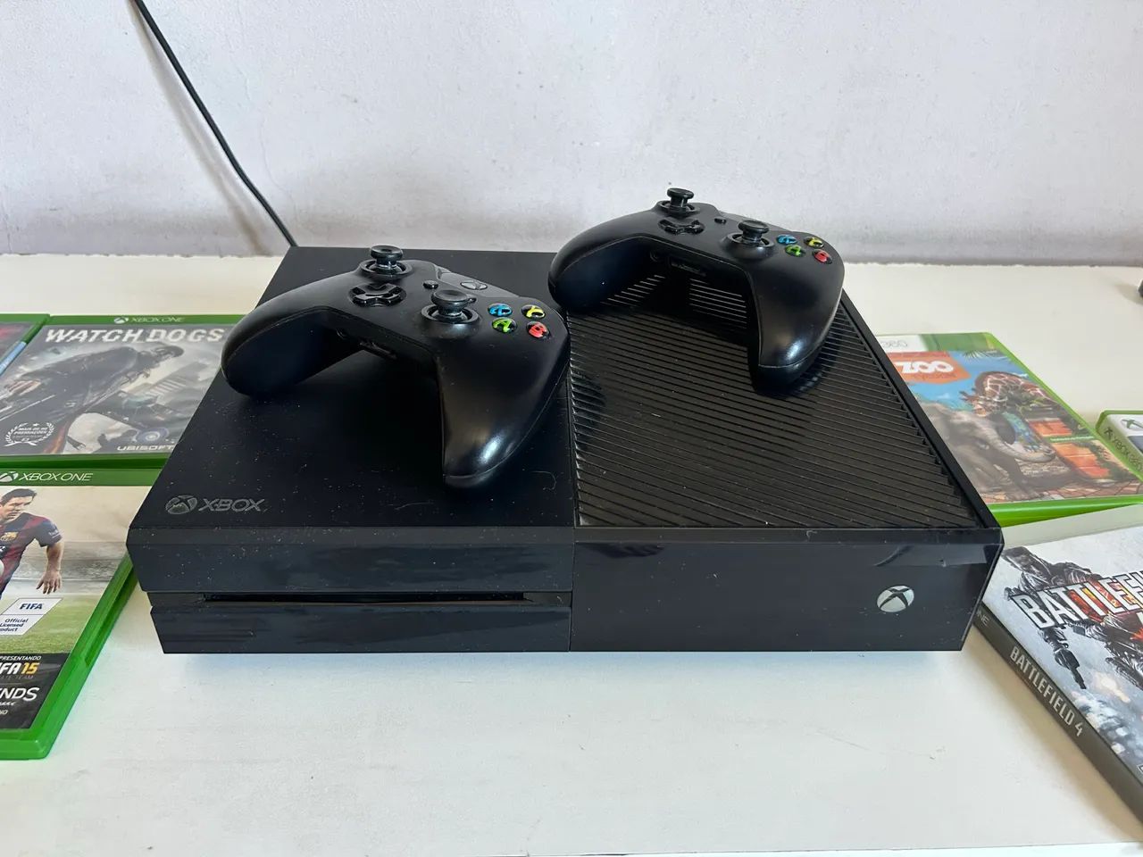 Xbox One com dois controles e jogos.