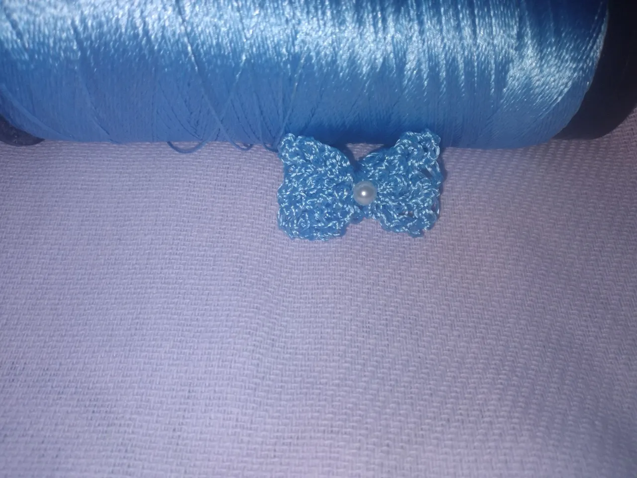 Laço de crochê azul com pérola