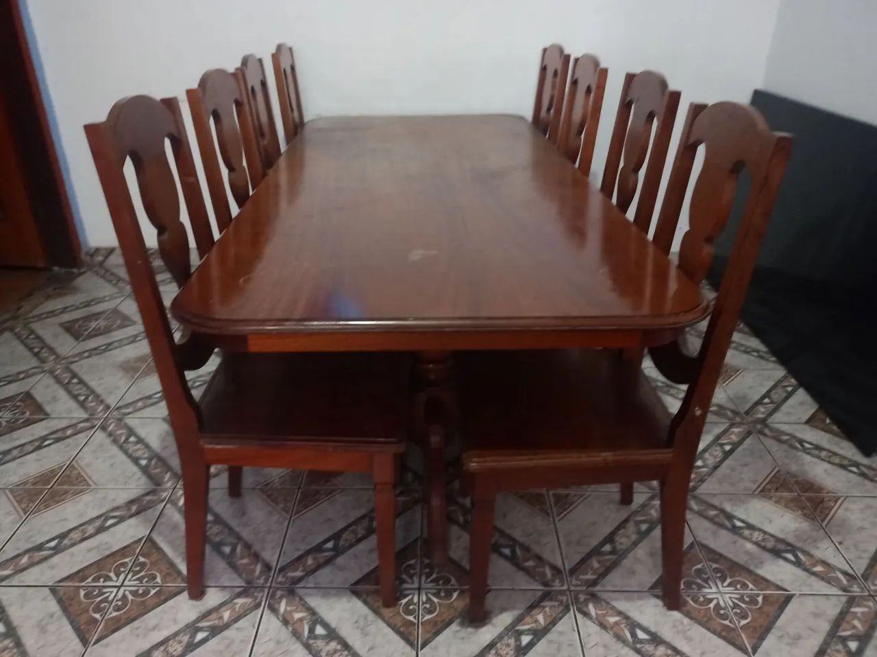 Mesa com 8 cadeiras de madeira maciça.