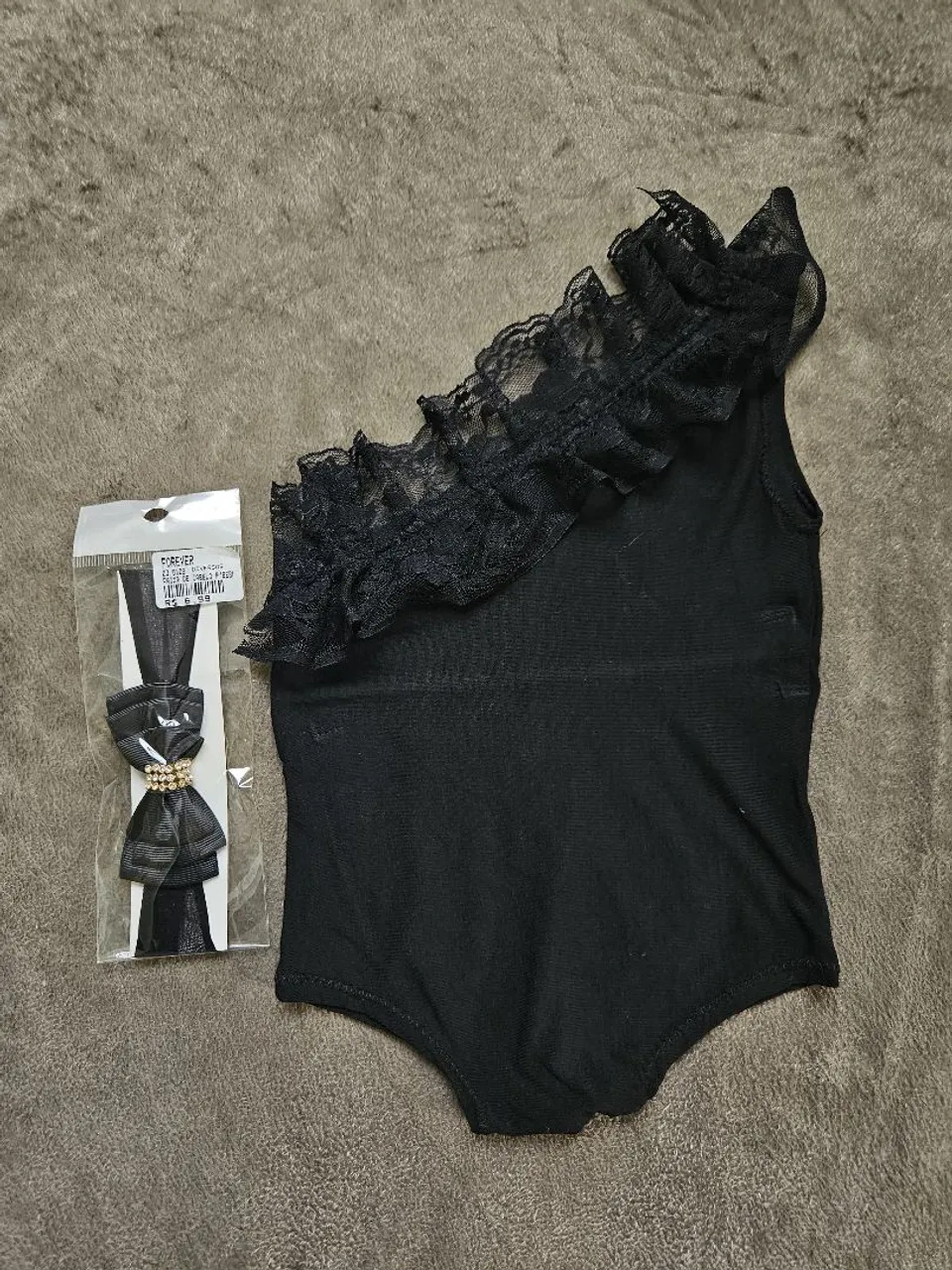 Body preto com babado e acessório de cabelo