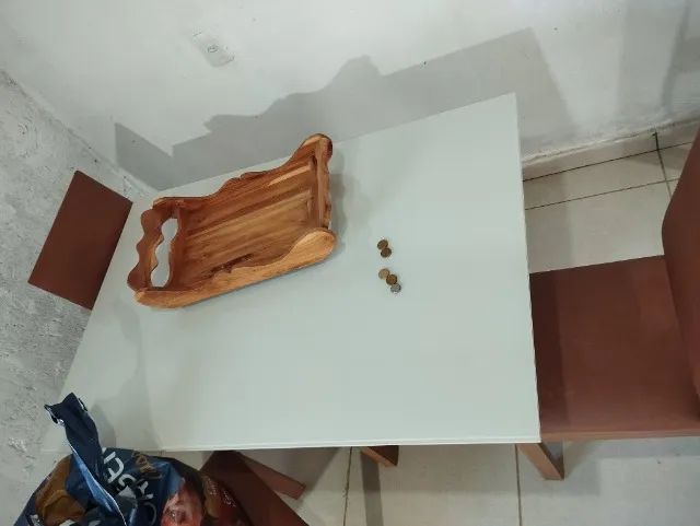 Mesa de baixo do vidro tem uma madeira branca. 