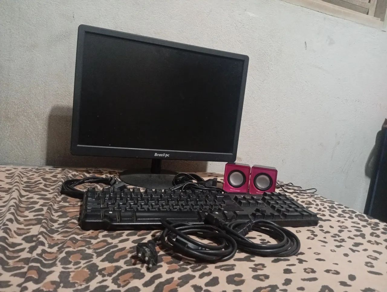 Vendo tela de computador teclado e caixinha de som e os cabos
