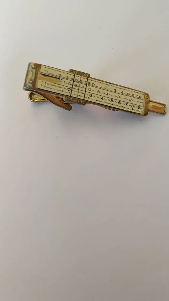 prendedor de gravata com régua de cálculo funcional (slide rule tie bar).