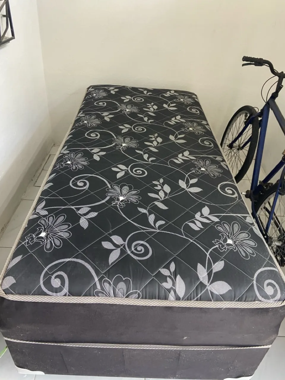 Cama de solteiro com colchão floral, de molas.