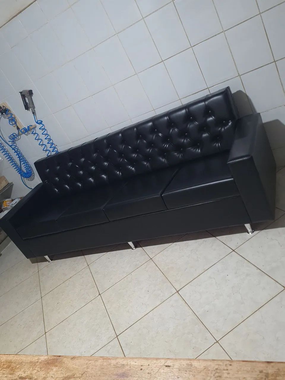 Sofá de quatro lugares com revestimento sintético