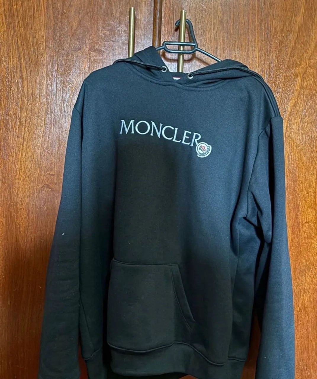 Moletom preto com capuz e logo da marca Moncler.