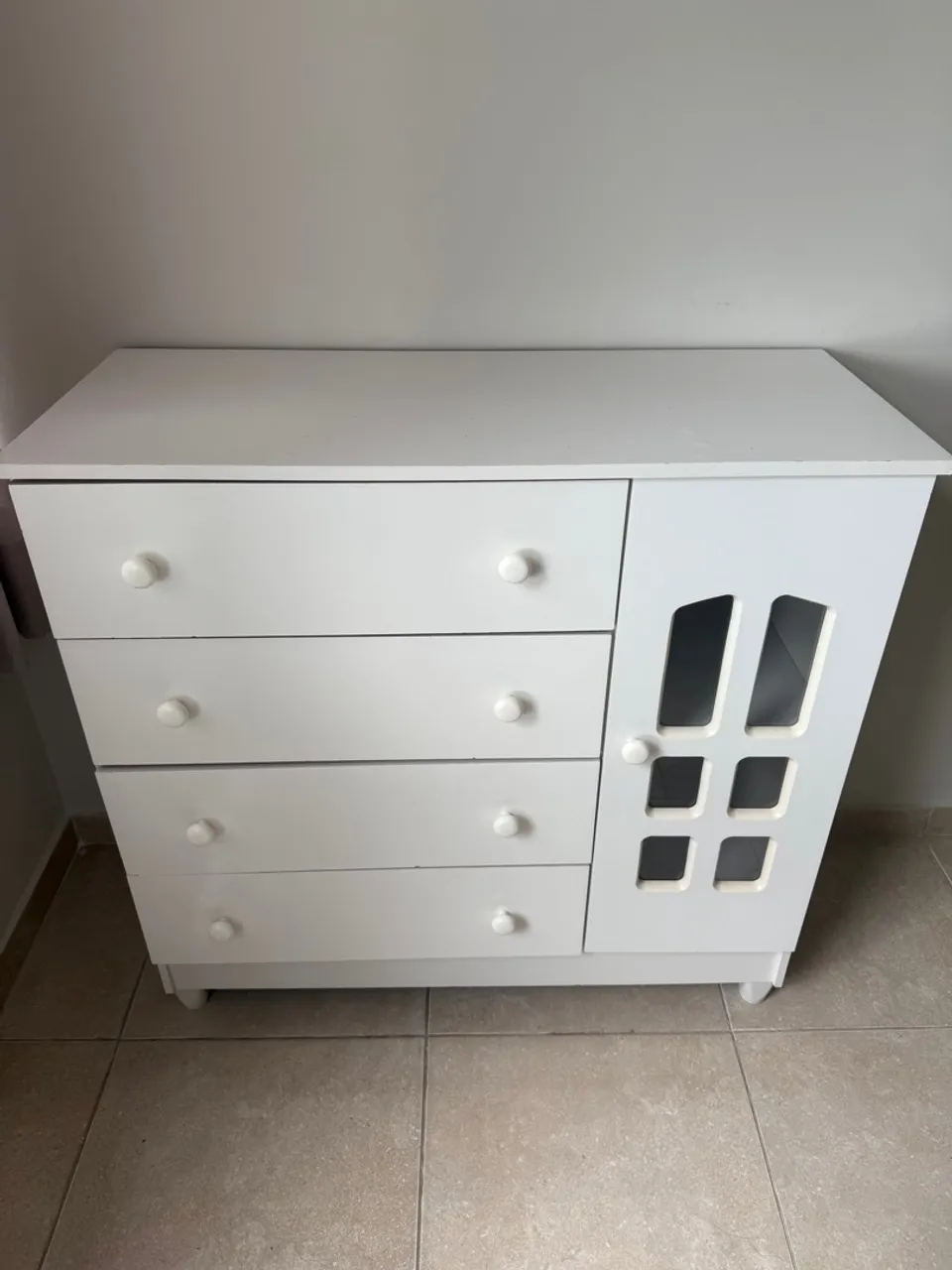 Cômoda branca com gavetas e porta decorada