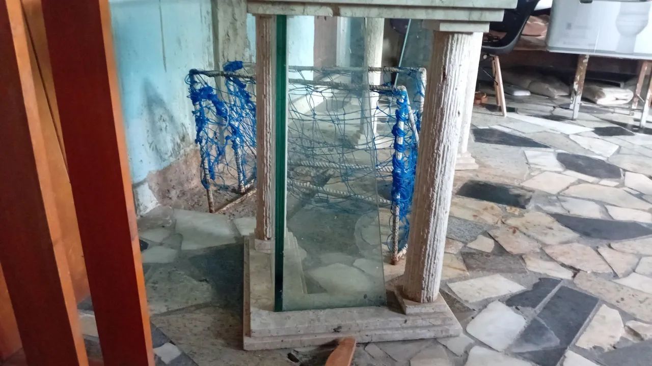 Mesa em vidro oval com suportes de granito.