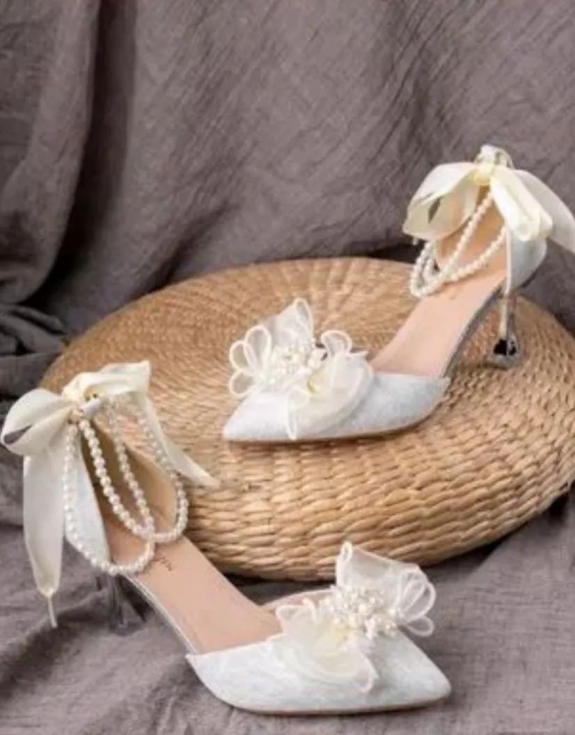 Sandália de salto alto prateada com pérolas e laço