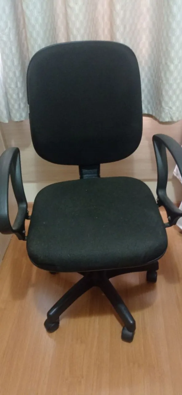 Cadeira de escritório preta giratória com rodinhas.