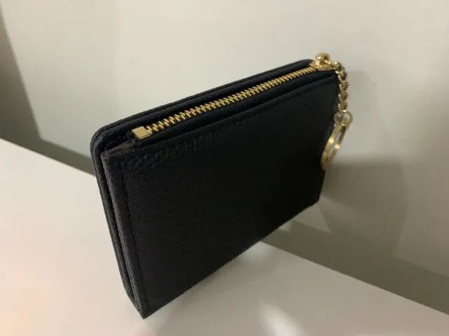  carteira preta com zíper e chaveiro dourado. 