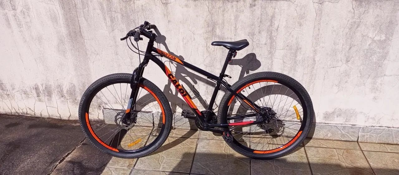 Caloi Vulcan aro 29, preta e laranja, com freios a disco. 