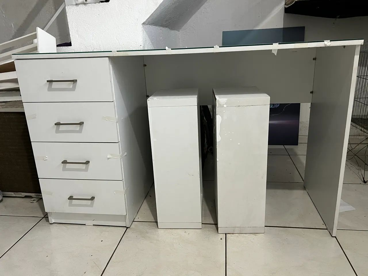 Mesa de escritório com 4 gavetas espaçosas, e vidro em cima.