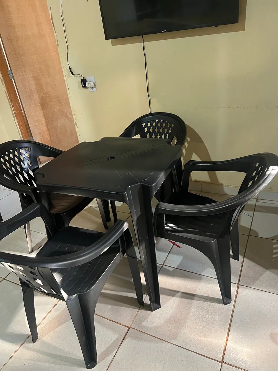 Mesa de plástico com quatro cadeiras.