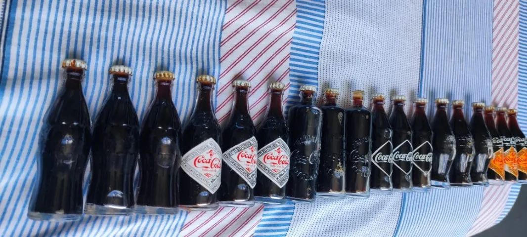 GARRAFINHAS COM MAIS DE UM SÉCULO DA EVOLUÇÃO VISUAL DA COCA-COLA