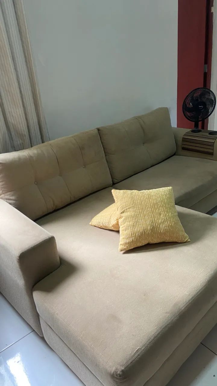 Sofá com chaise na cor bege.