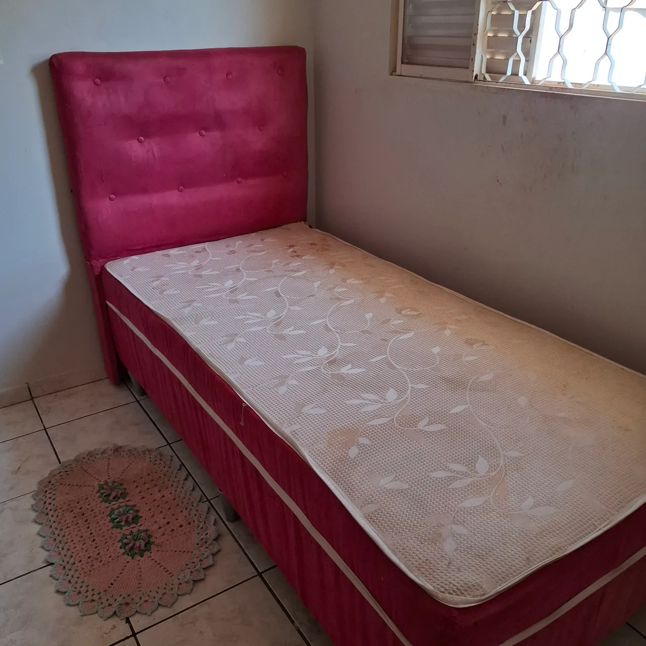 Cama de solteiro com cabeceira estofada.