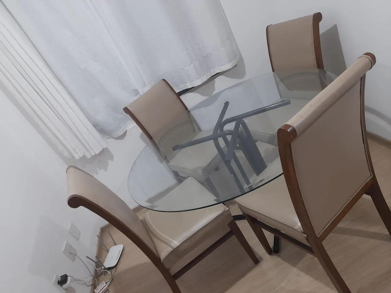 Mesa de vidro com 4 cadeiras e um sofá 