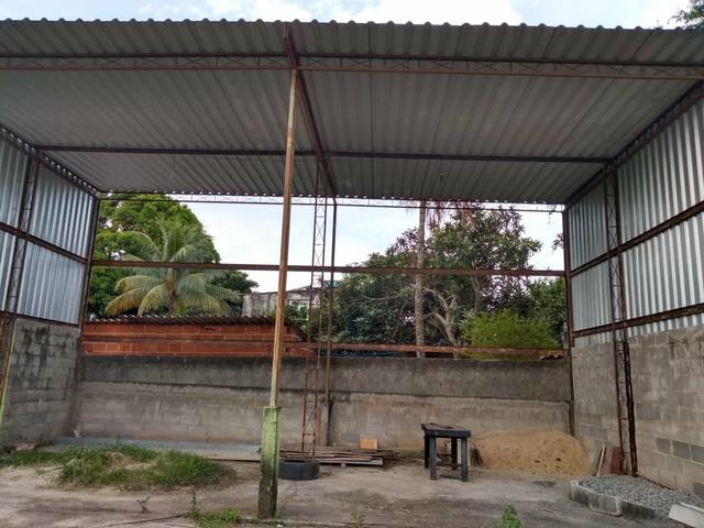 Casa com terreno murado e galpão