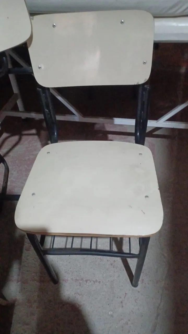 Cadeiras escolares tradicionais, com pés de ferro.