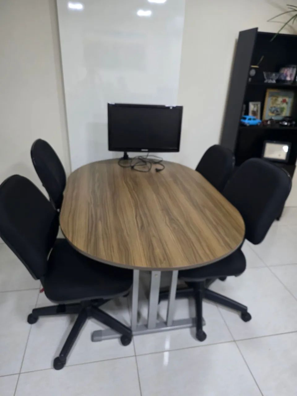 Mesa de reunião com 4 cadeiras acolchoadas.