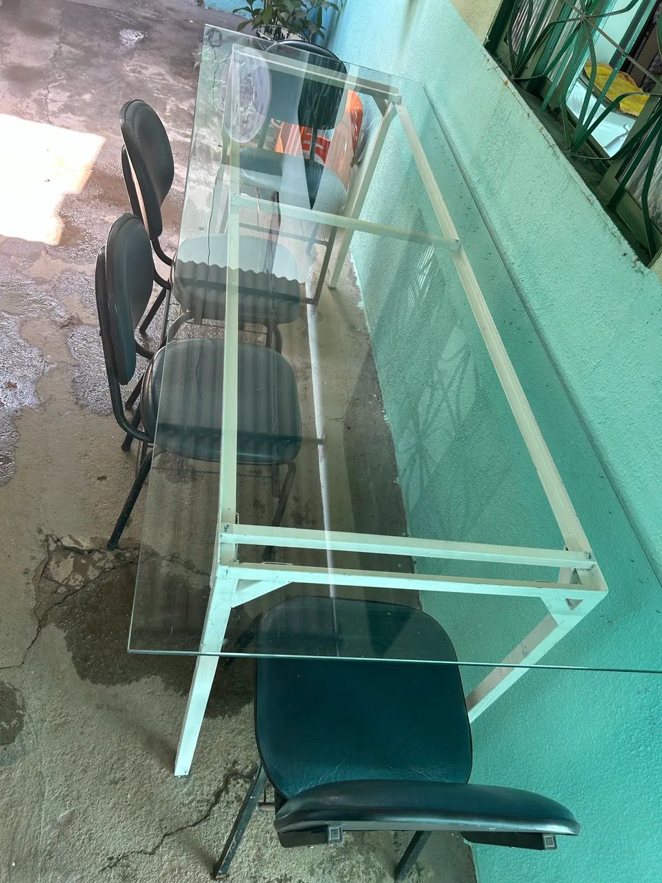 Mesa de vidro com pés de metal.