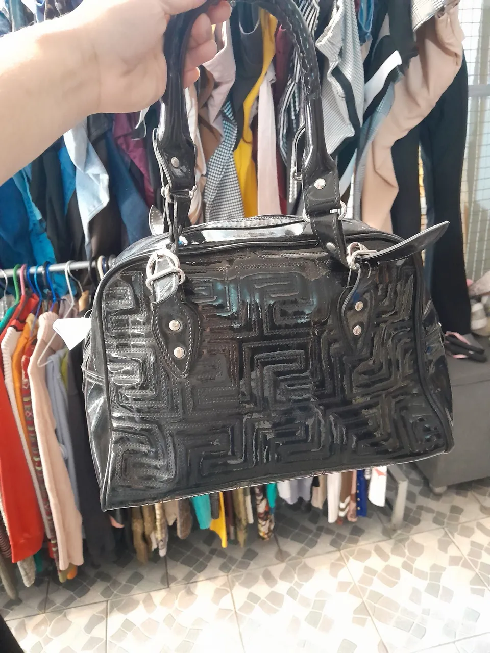 Bolsa de mão preta com detalhes em relevo