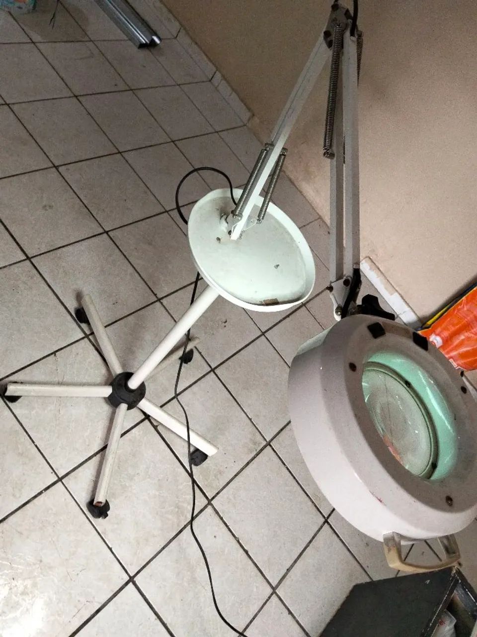 luminária com lupa articulada e tripé de rodinhas.