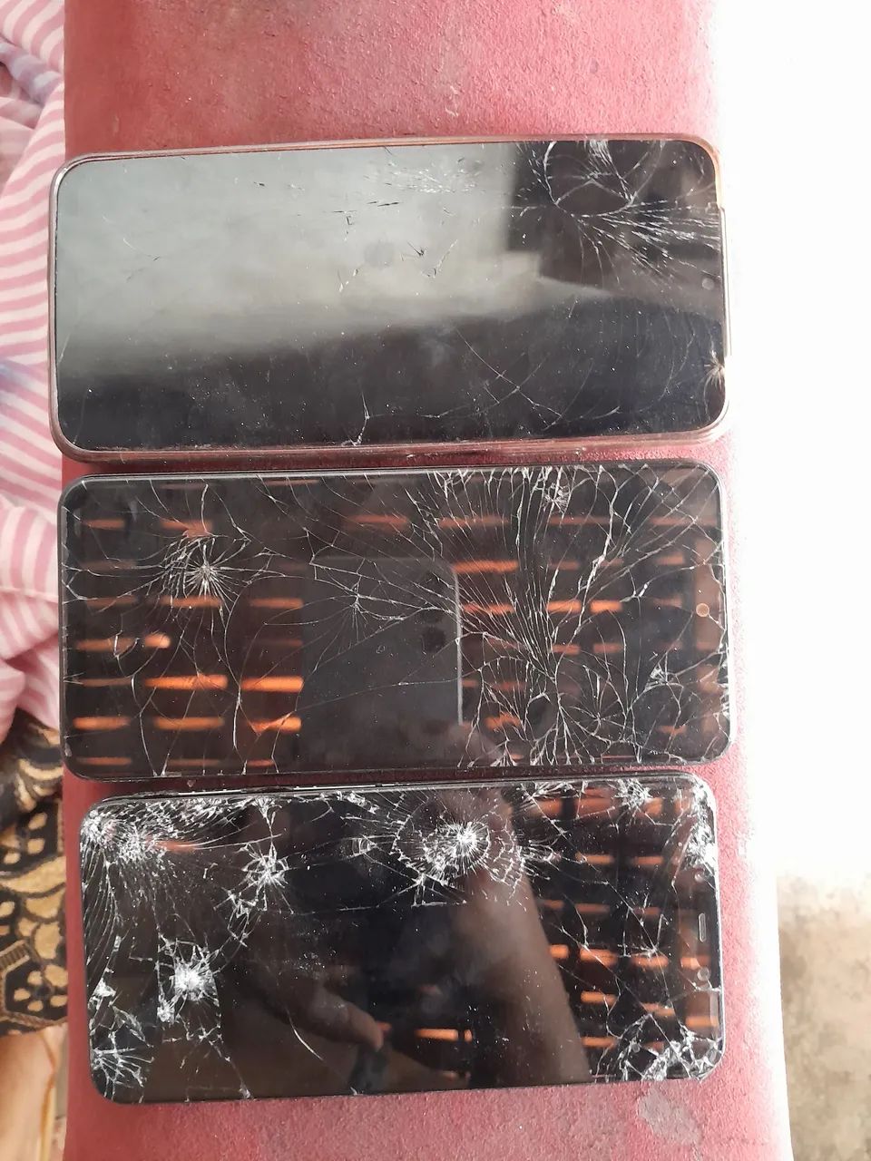Celular com tela quebrada.